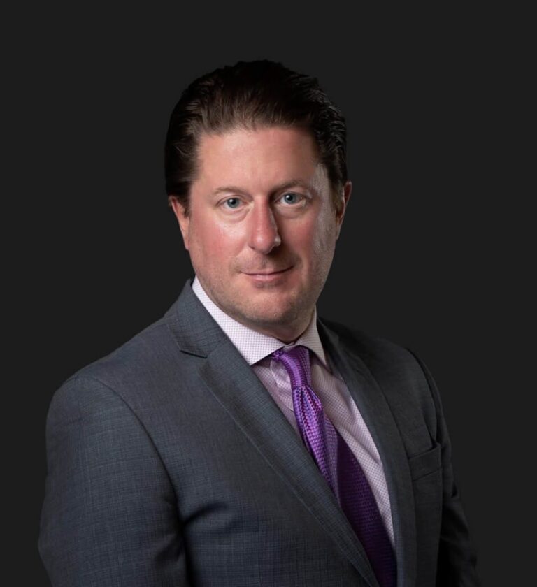 Attorney Toby P. Mulholland in a dark suit and purple tie